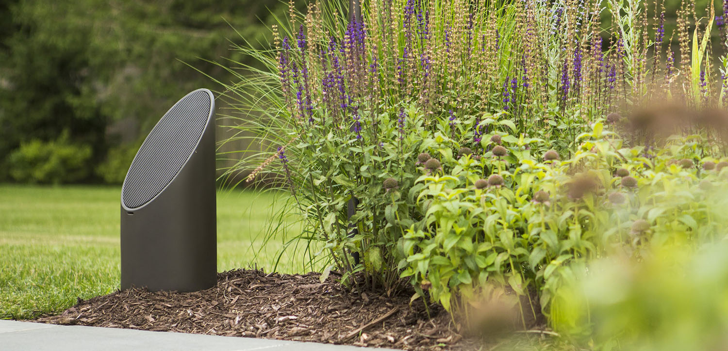 Bollard-style speaker set in garden greenery